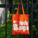 Bright Outdoor Tote Bag Mockup Hanging on Fence