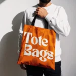 Hand Held Tote Bag Mockup with Sunlight on White Wall