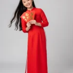 Model of a girl wearing a red ao dai holding a lucky money bag tết cô gái mặc áo dài đỏ cầm bao lì xì